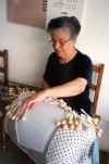 A woman practicing the art of pillow lace